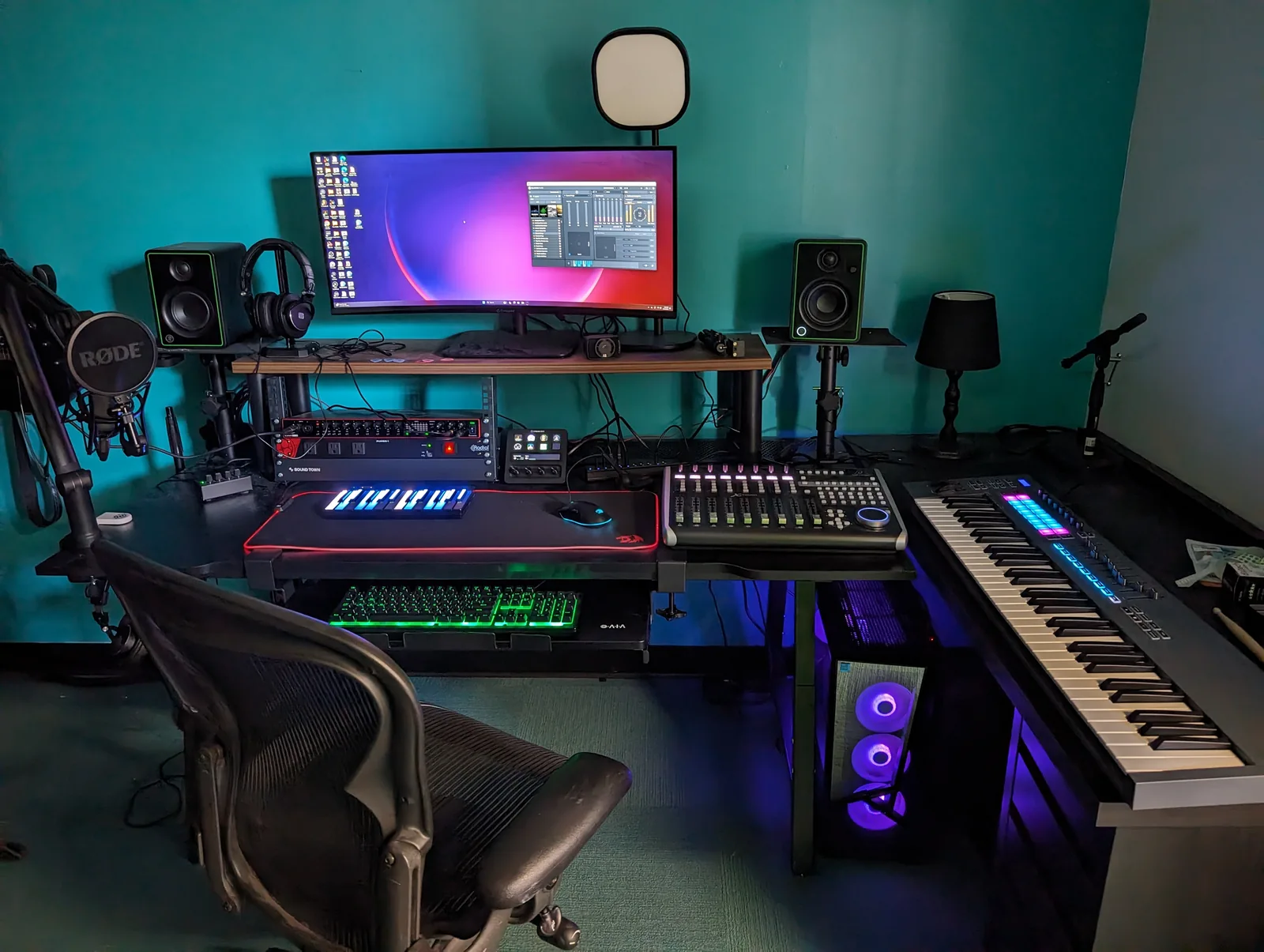 Audio workstation with a microphone, keyboard, mixing controls and monitor