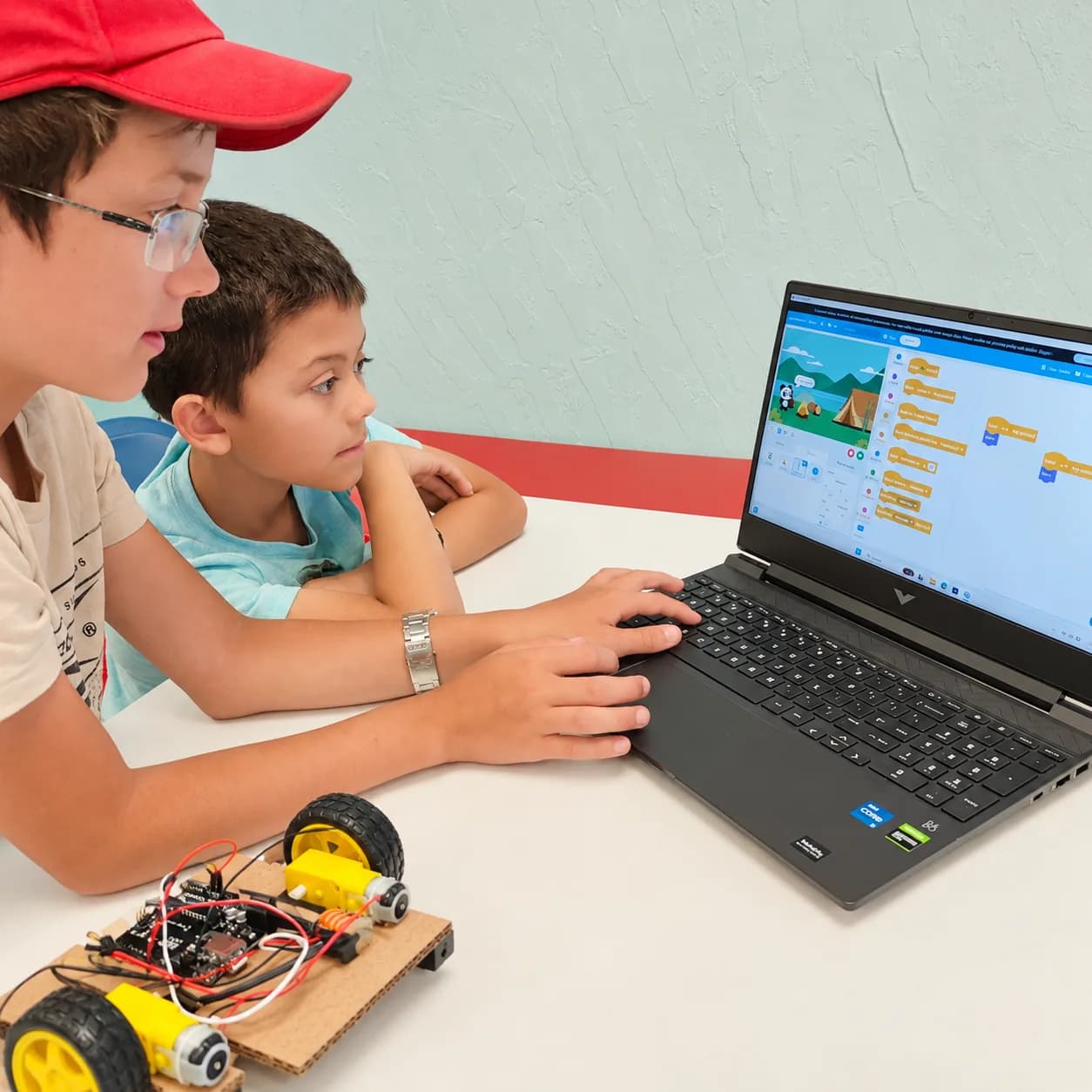 A young learner exploring visual coding alongside a mentor